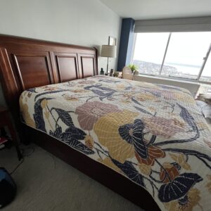 Wood panel bed frame with tall paneled headboard in warm brown finish.
