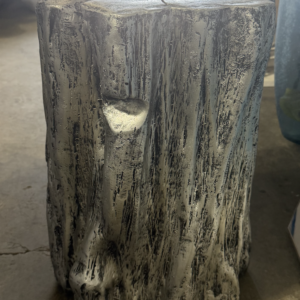 Gray faux tree stump accent table with textured sculpted surface and flat top.