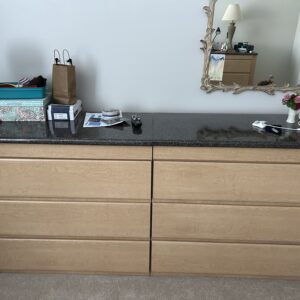Light wood six-drawer dresser with dark stone top.