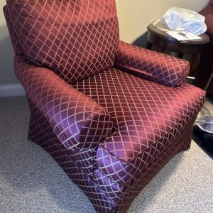 Burgundy diamond-pattern upholstered accent chair.