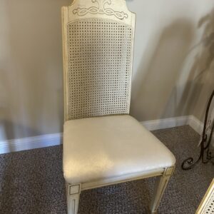 Set of four cream cane-back dining chairs.