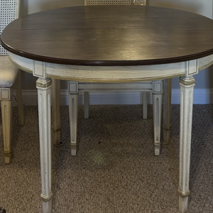 Round dining table with dark wood top.