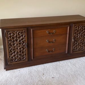 Wood sideboard cabinet with carved doors and drawers.